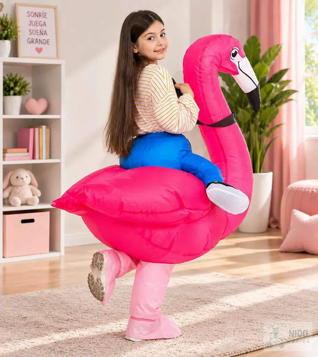 Niña montada en el disfraz inflable de flamenco rosado